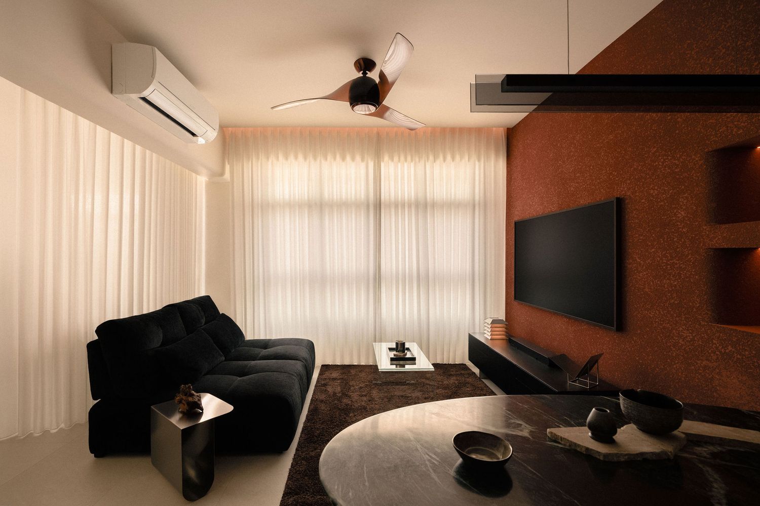 Modern living room with a black tufted sofa, sheer white curtains, ceiling fan, wall-mounted TV on a textured terracotta accent wall.