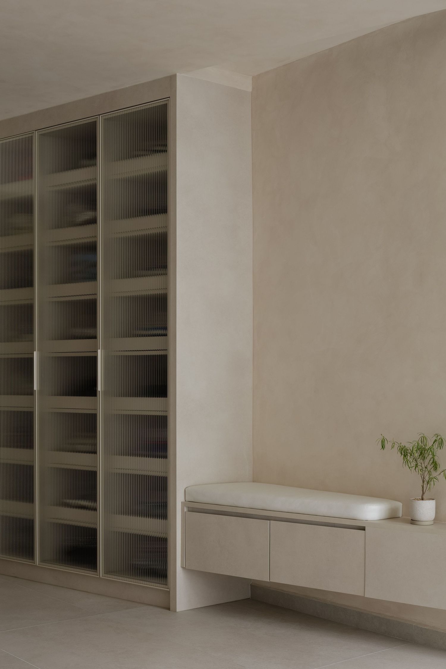 Modern white built-in shelving unit with clean lines and minimalist design features floating cabinets and storage spaces.