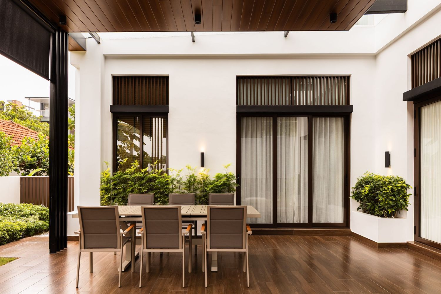 Modern apartment interior with white walls features long horizontal windows and wood beam accents in a minimalist design.