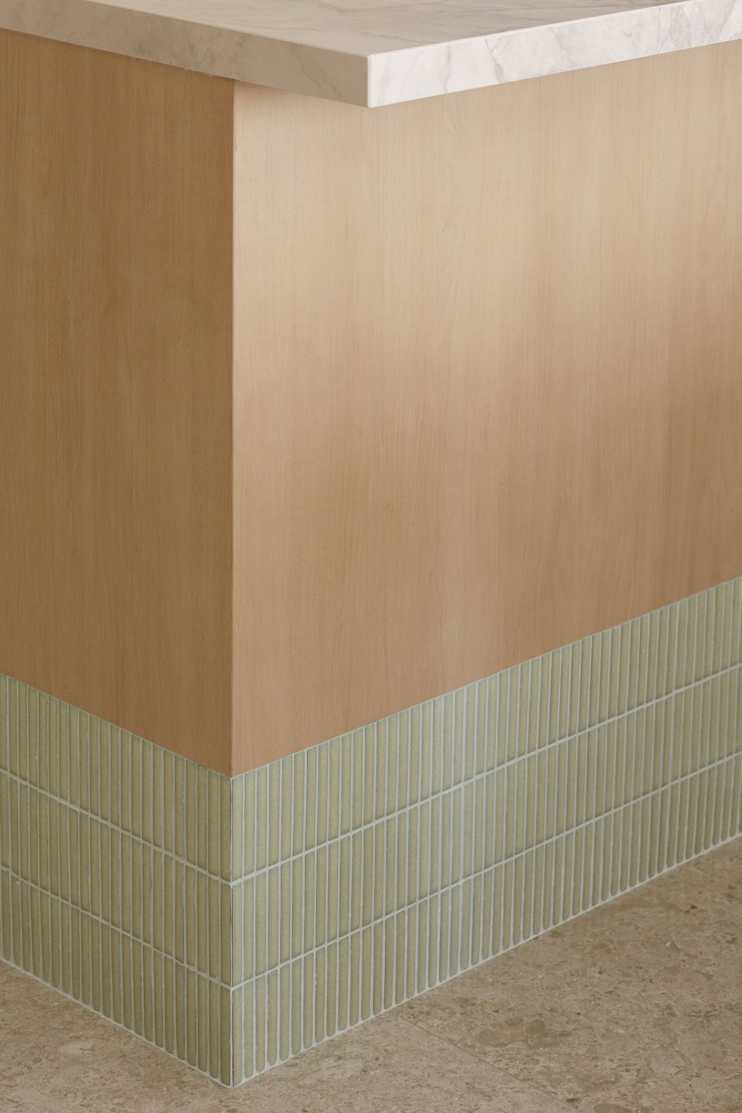 Architectural detail showing light beige walls with sage green wainscoting panels creating a clean, modern interior design.