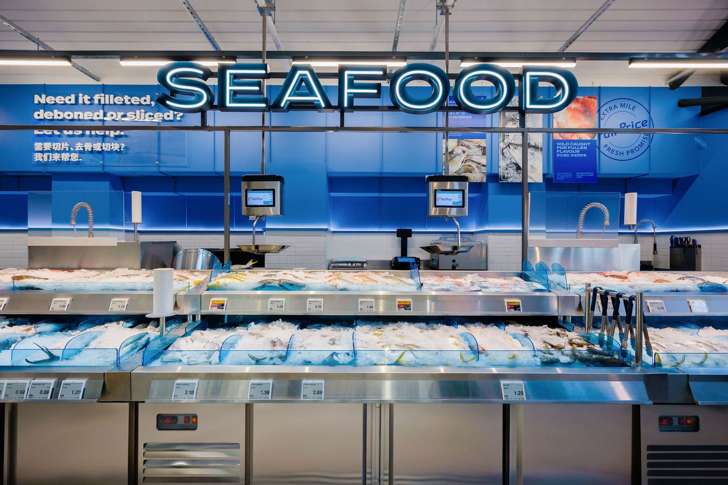 Supermarket seafood counter with a glowing SEAFOOD sign above refrigerated displays of fresh fish and shellfish on ice.