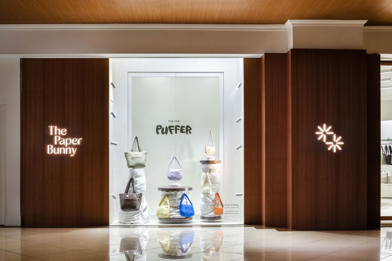 Storefront of The Coffee Bunny cafe with wood paneling and illuminated display window showcasing glass coffee decanters.