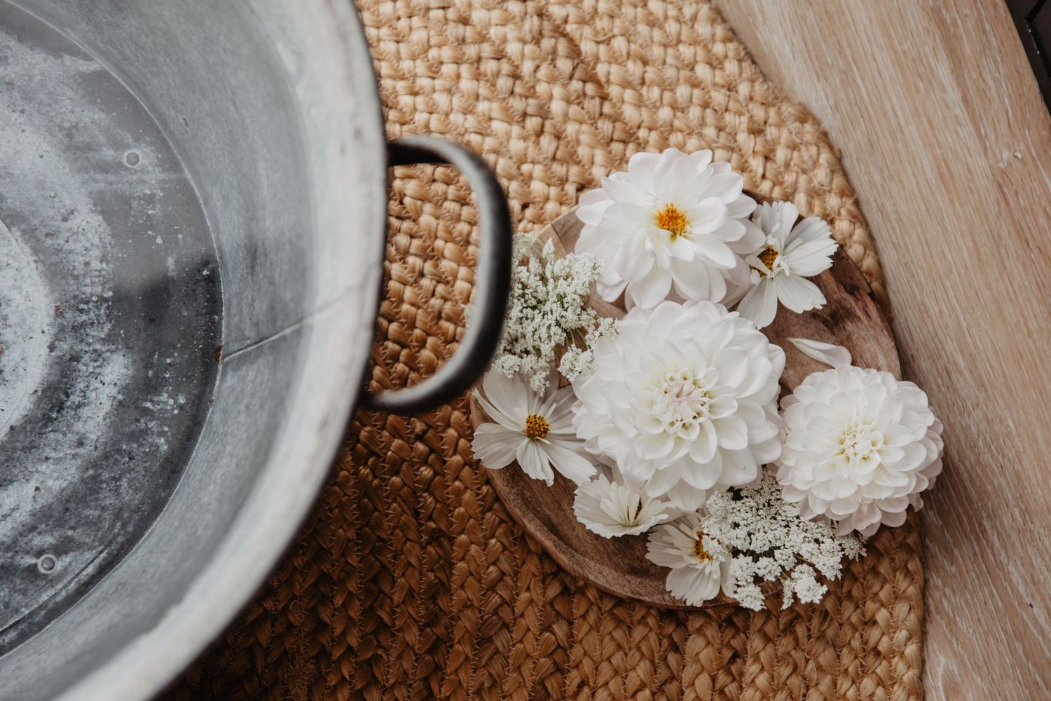 Dahlias blancs et marguerites à côté d'un bain fleuri