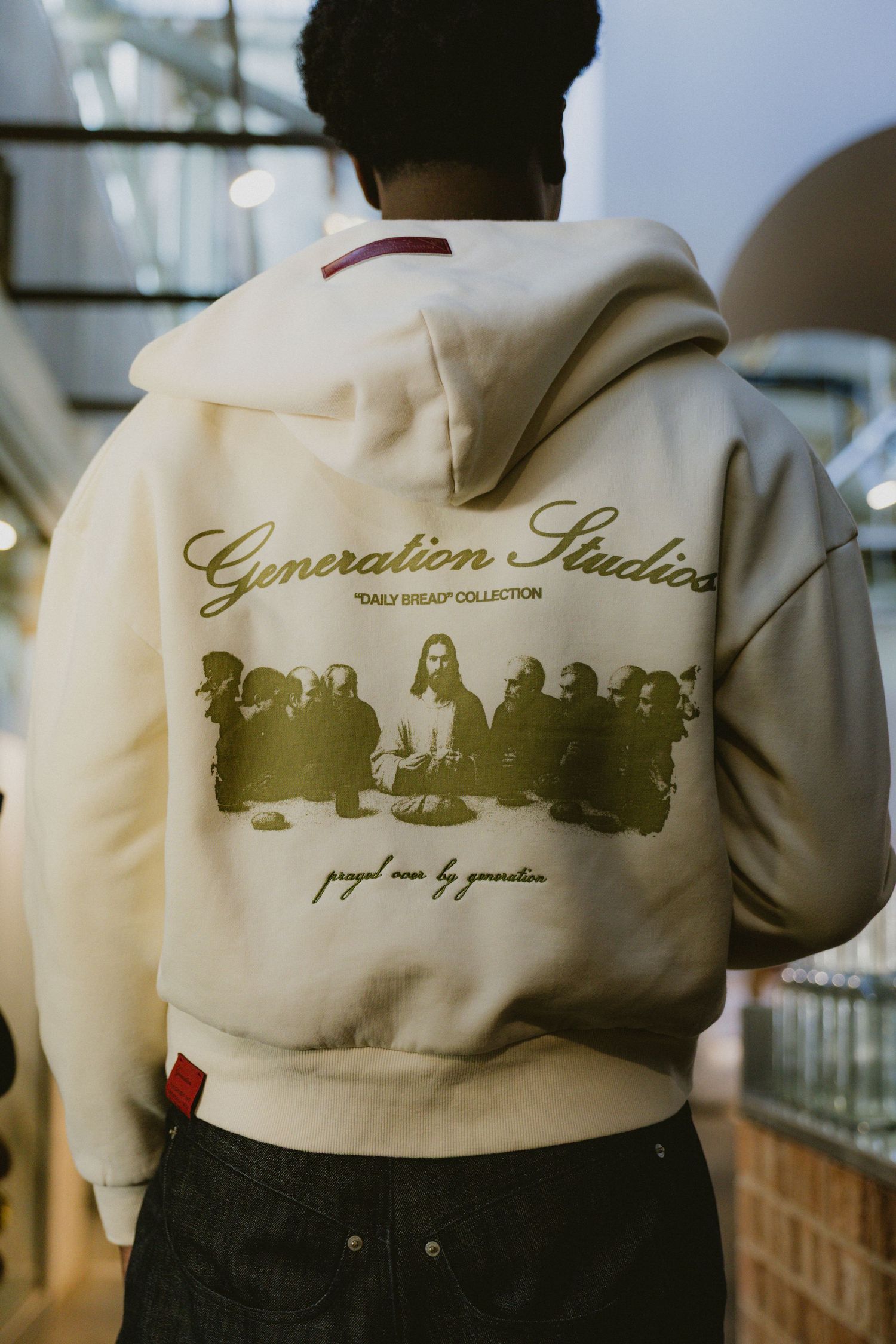 Back view of cream Generation Studios Daily Bread Collection hoodie with Last Supper graphic print.