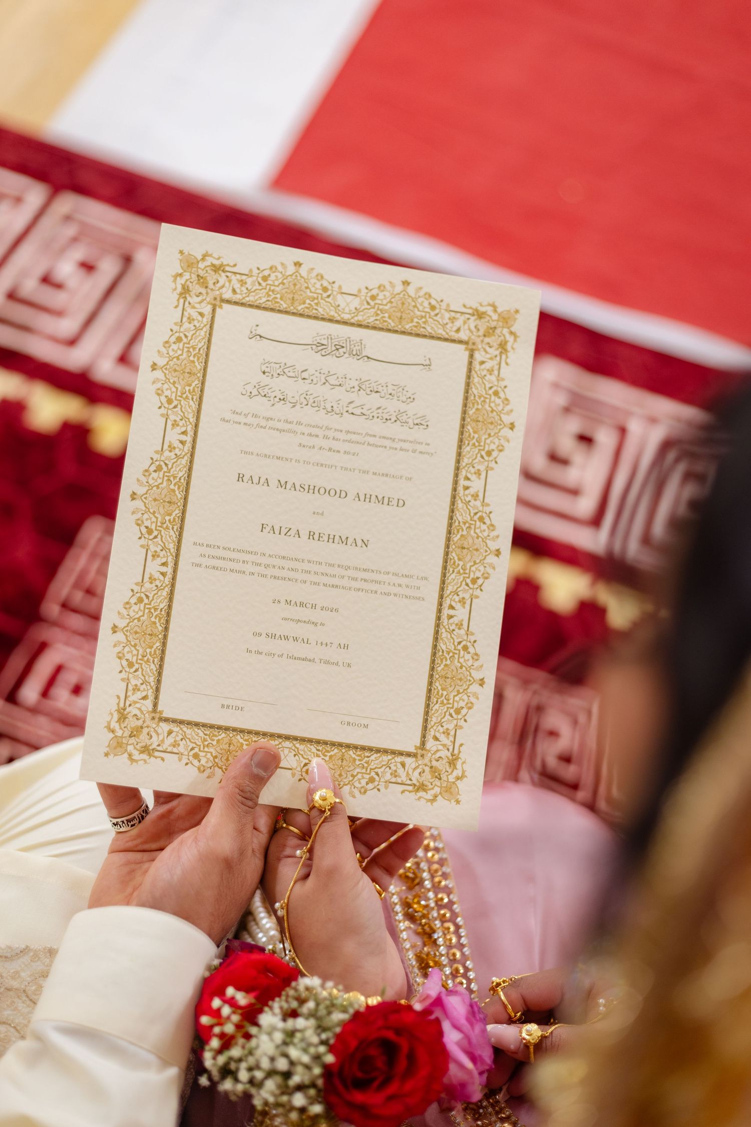 Hands hold ornate gold-bordered Islamic nikah certificate during South Asian wedding ceremony in london.