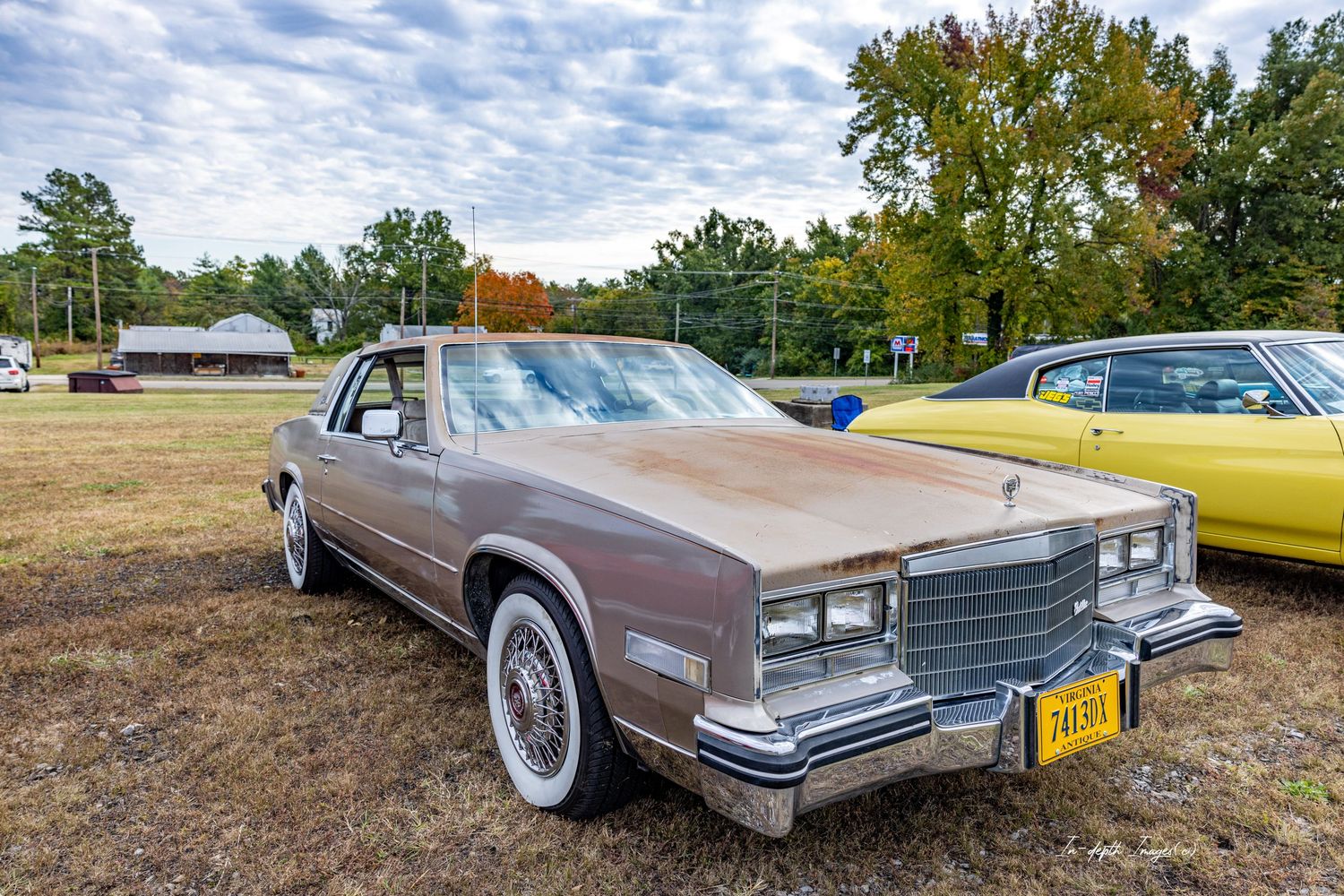 A vintage brown Cadillac Eldorado classic car on display at an outdoor car show on a cloudy day.