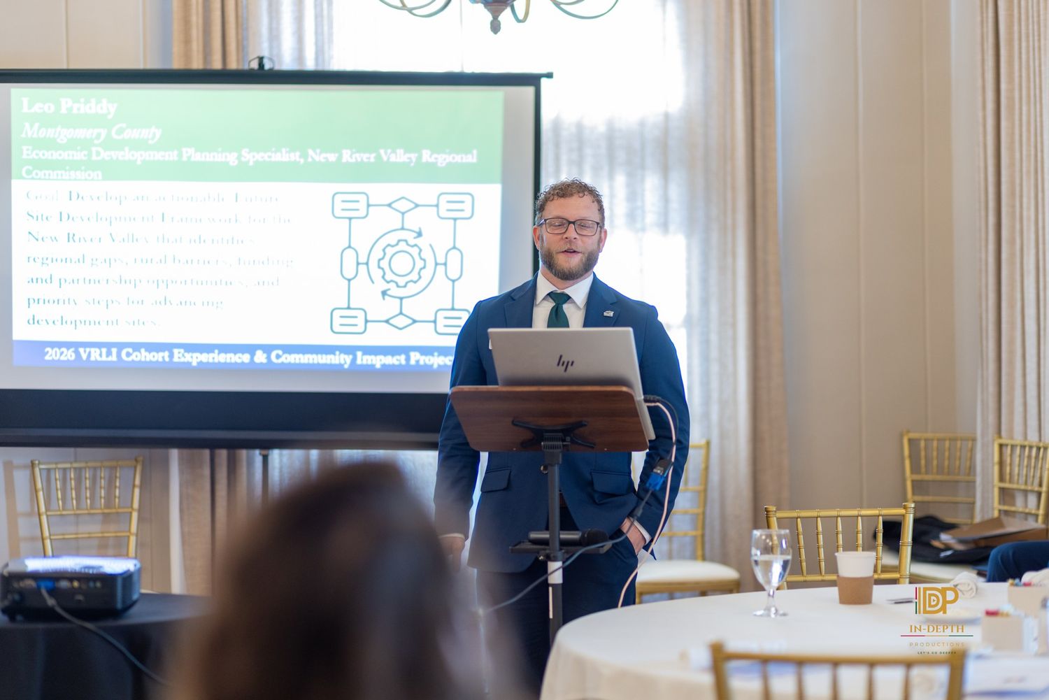 A participant presenting beside a project slide during the VRLI graduation program.