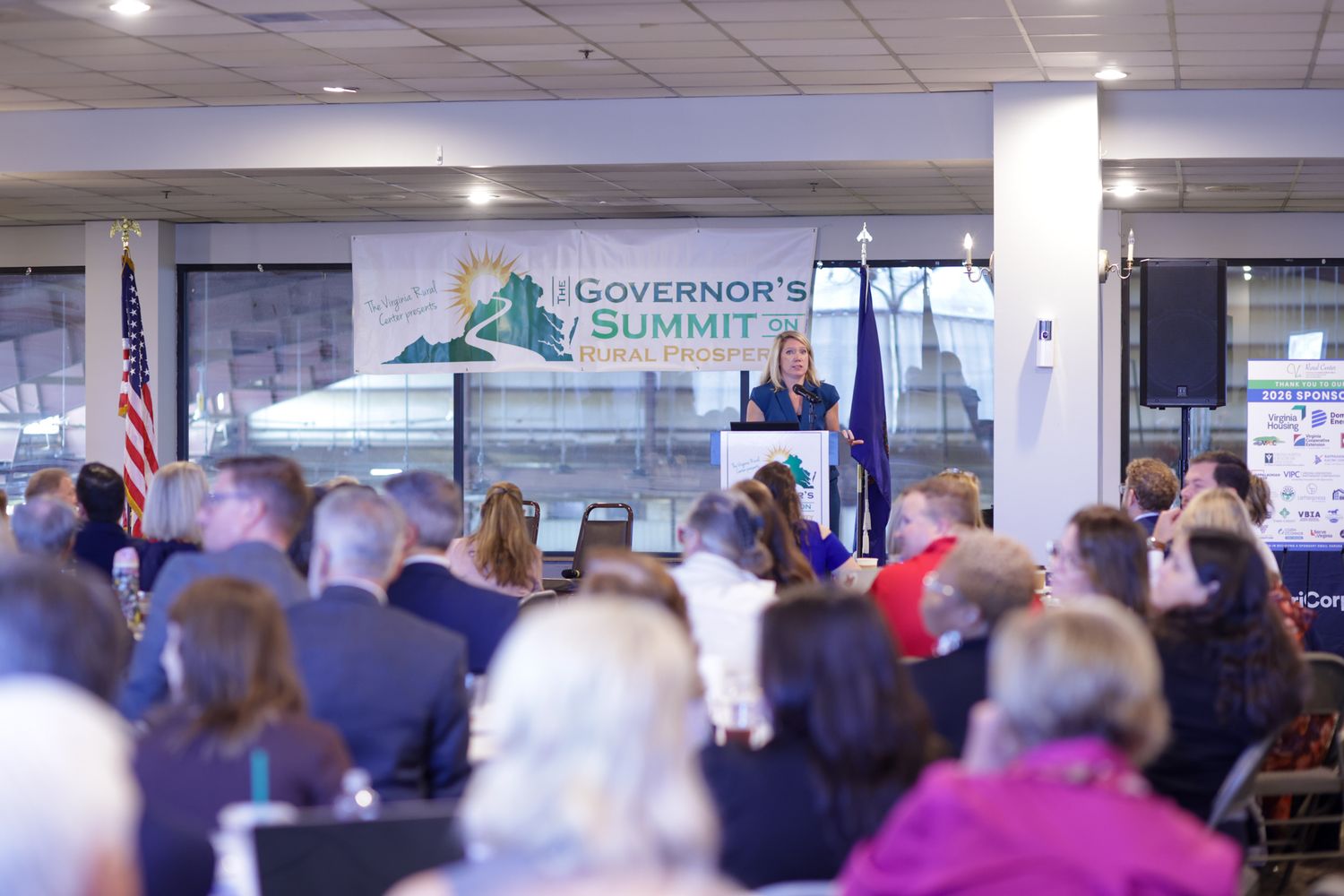 Speaker addresses attendees at the Governor's Summit on Rural Prosperity in a packed conference room.