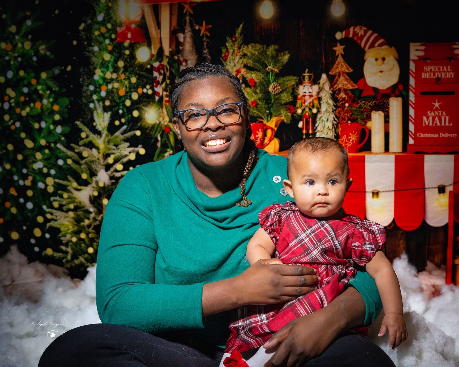 Smiling woman holding baby in festive Christmas portrait session.