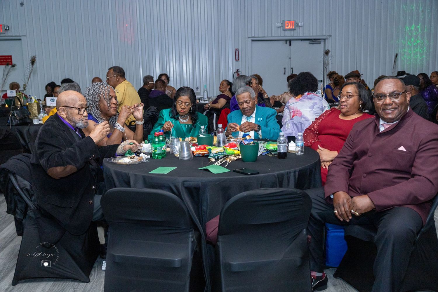 Guests seated at black round tables enjoying a festive banquet or celebration event indoors.