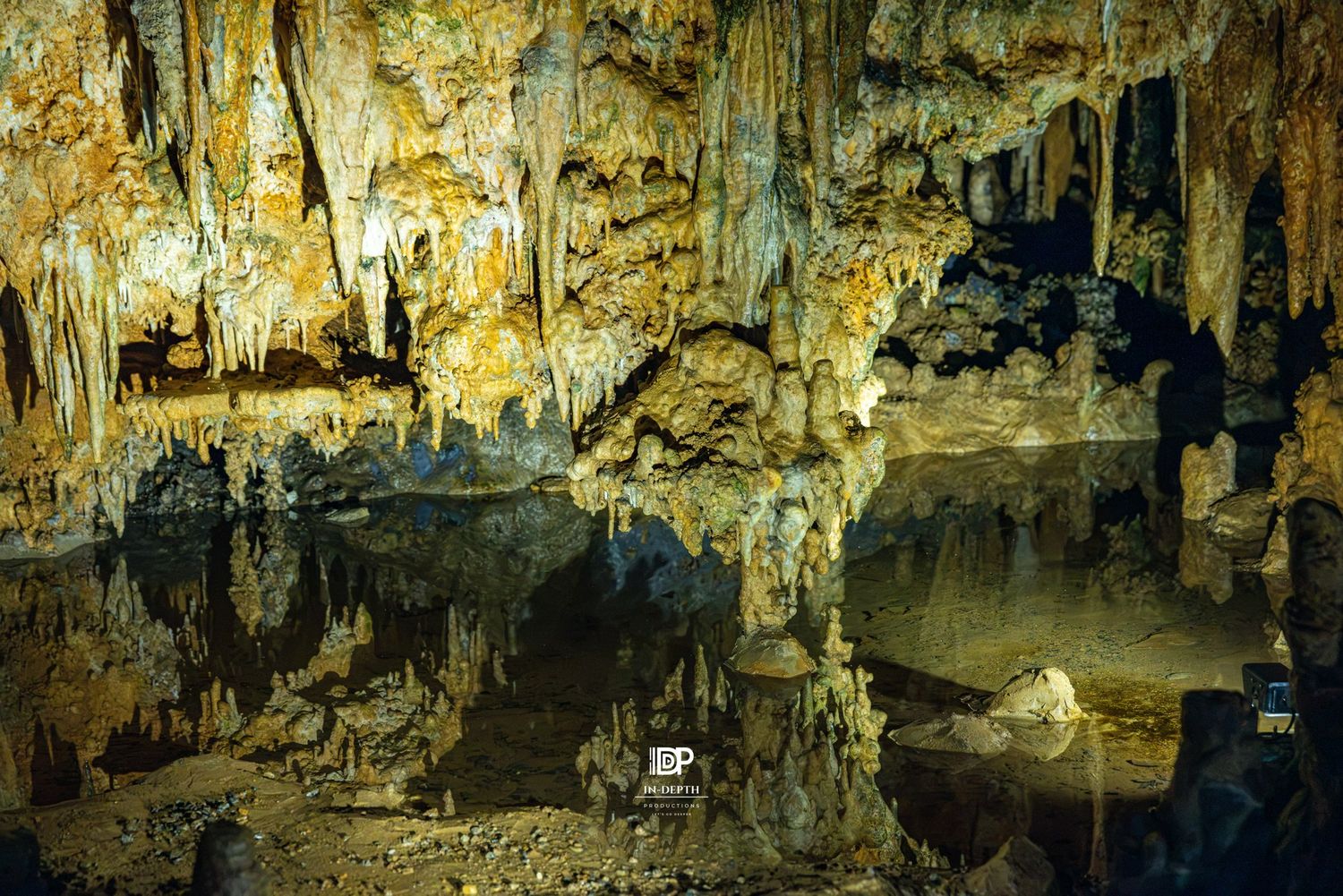 Illuminated cavern formations reflected in still water at Luray Caverns.