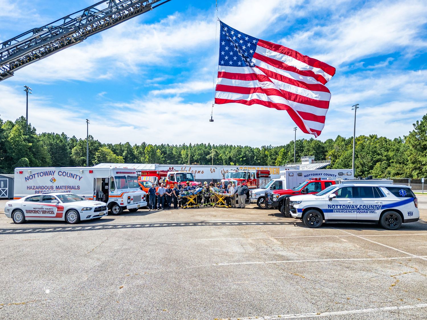 Nottoway County emergency response vehicles displayed outdoors under a large American flag on a sunny day.