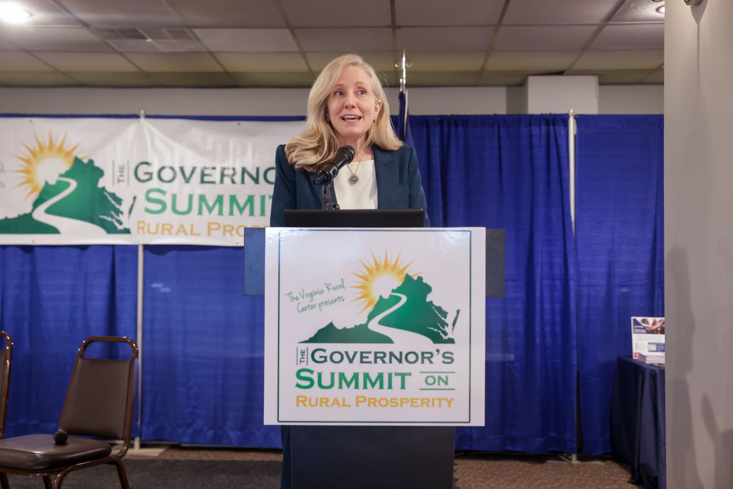 Woman speaking at podium during Virginia Governor's Summit on Rural Prosperity conference event.