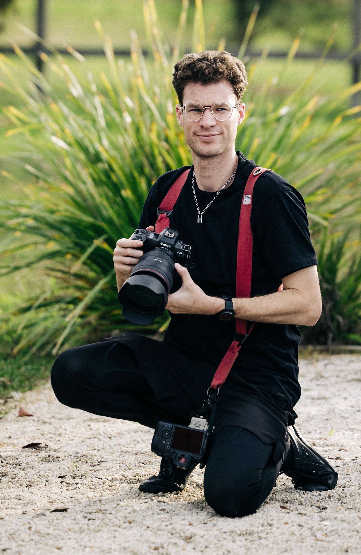 Sol from Vision Collective crouching holding a camera.