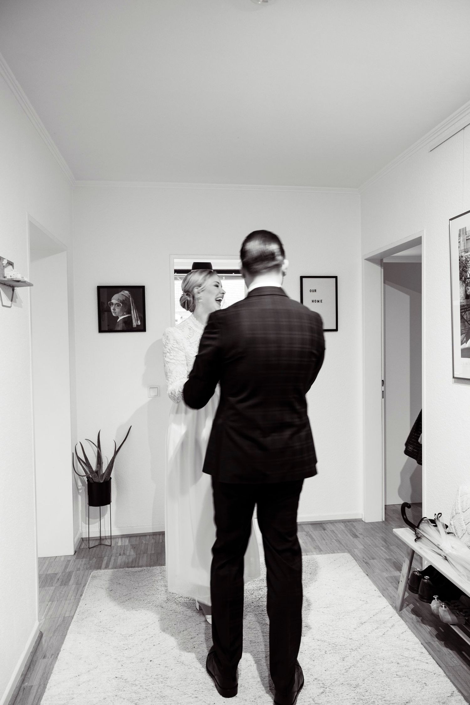 Black and white photo of bride and groom sharing intimate first look moment indoors.