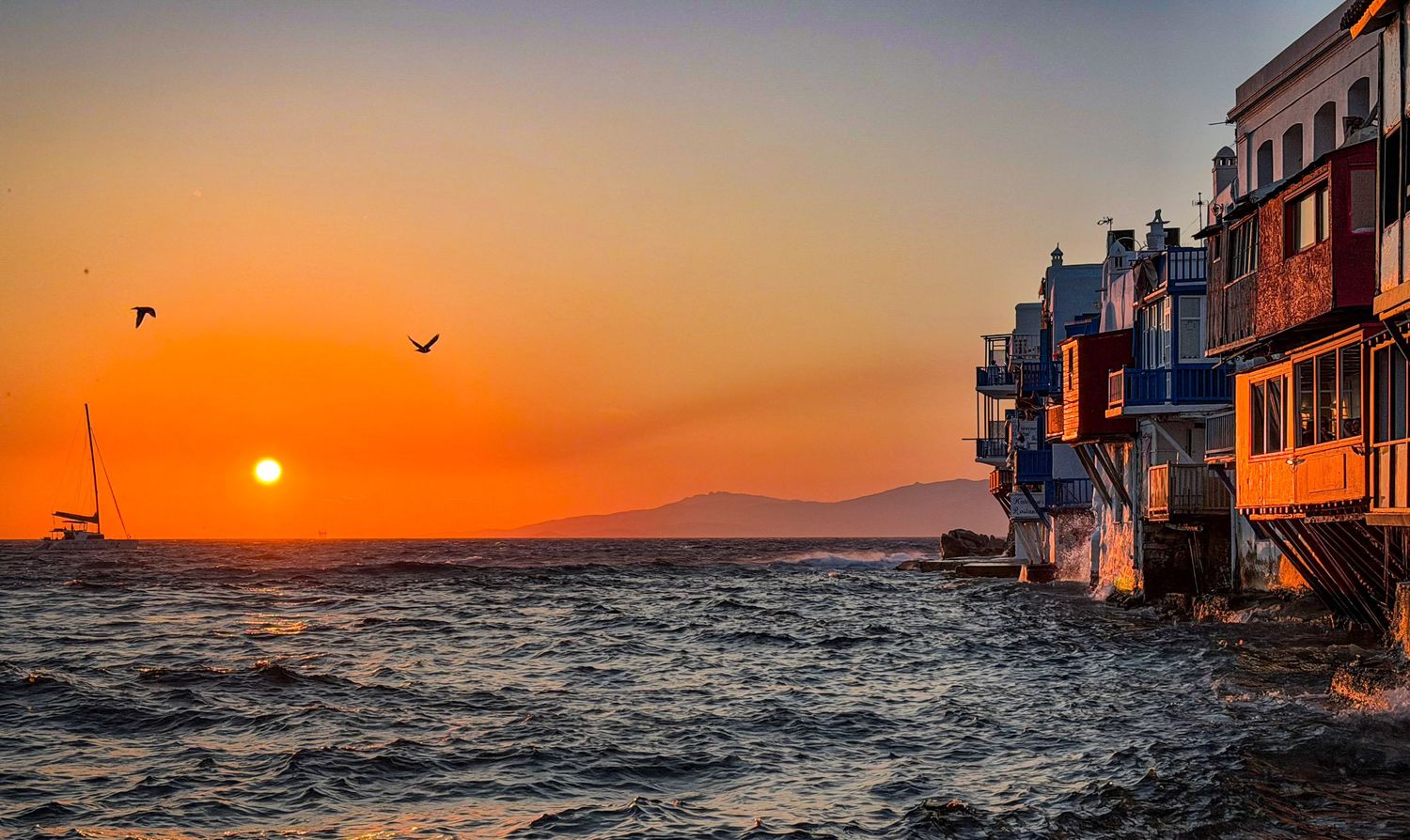 Sunset over the Aegean Sea beside Little Venice in Mykonos Town, Greece