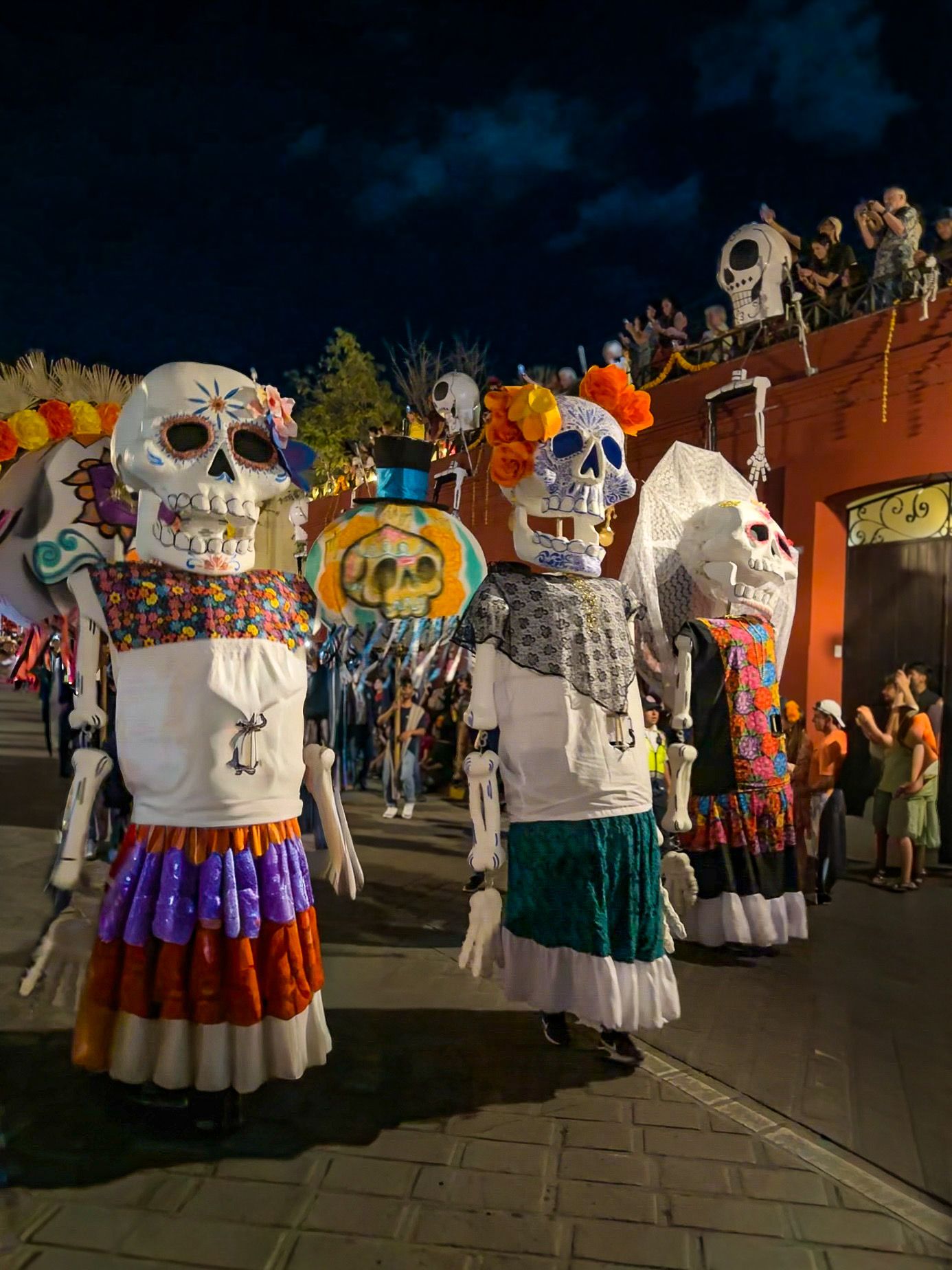 Giant dancing calavera figures in a Día de Muertos parade
