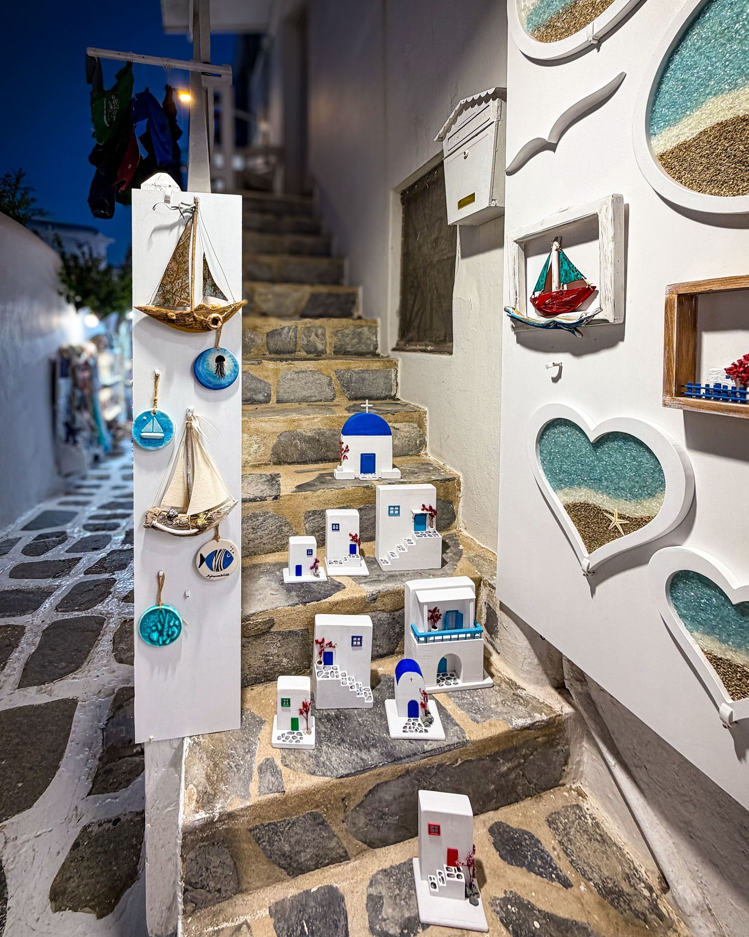 Shop display along a narrow whitewashed lane in Mykonos Town, Greece