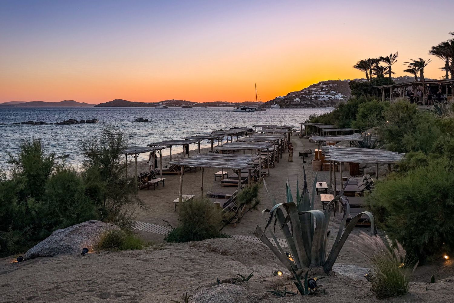Beach cabanas along the Aegean Sea at sunset at Scorpios Mykonos in Greece