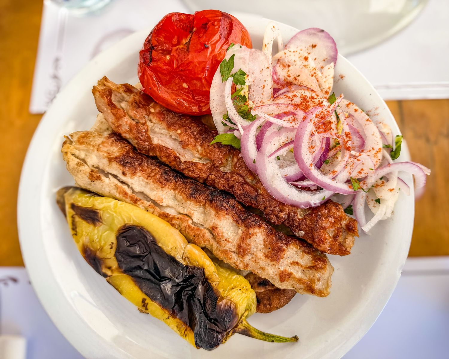 Kebab portion with grilled tomato, pepper, and red onion served at Proedros in Mykonos Town, Greece