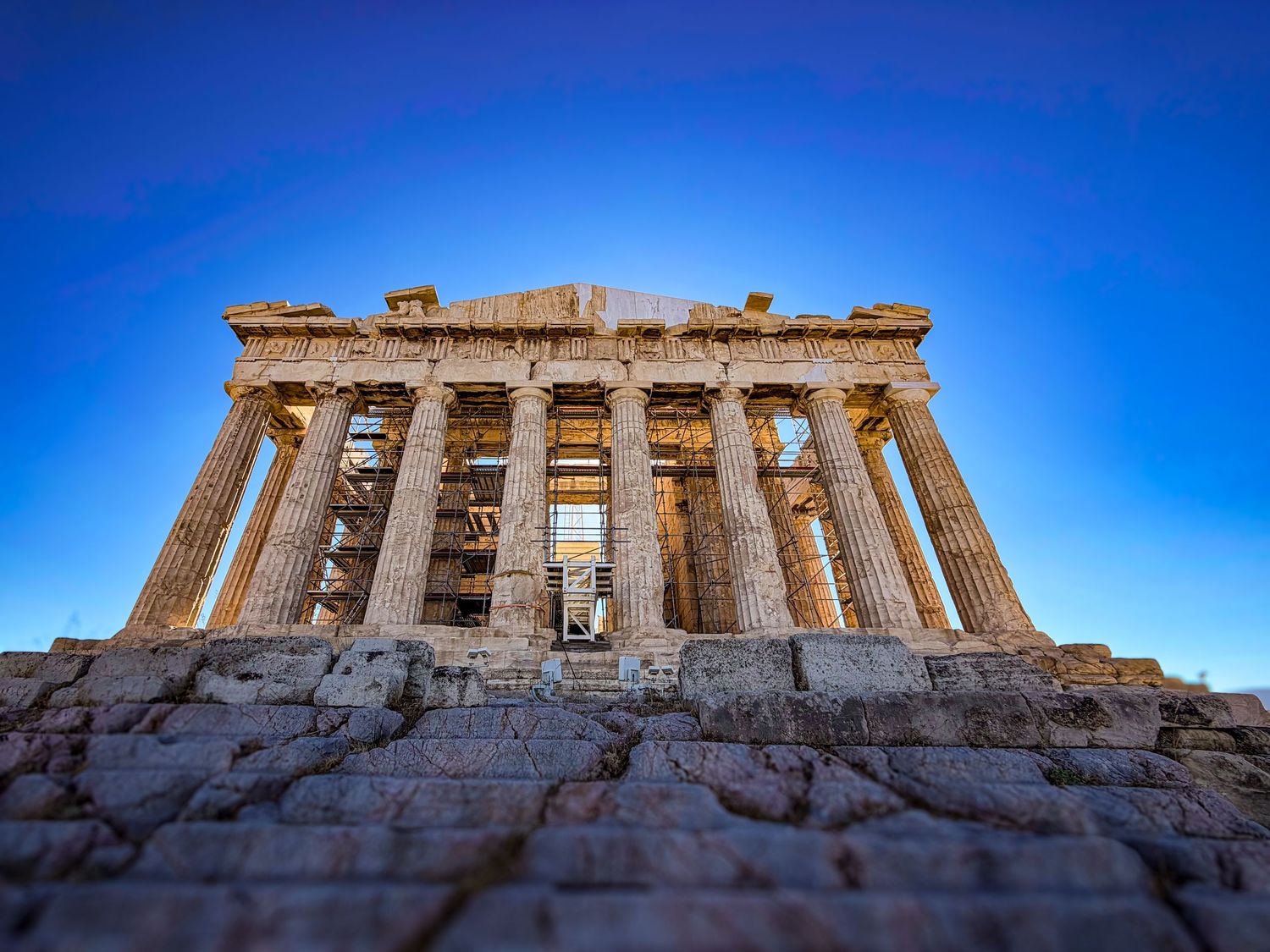 The Parthenon atop the Acropolis under a blue sky in Athens, Greece