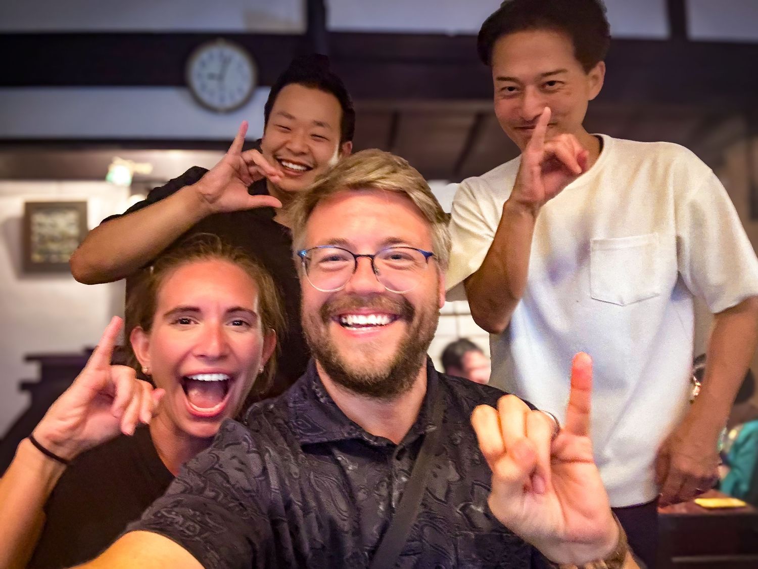 Tim and Amanda sharing a fun moment with locals at a bar in Kanazawa, Japan