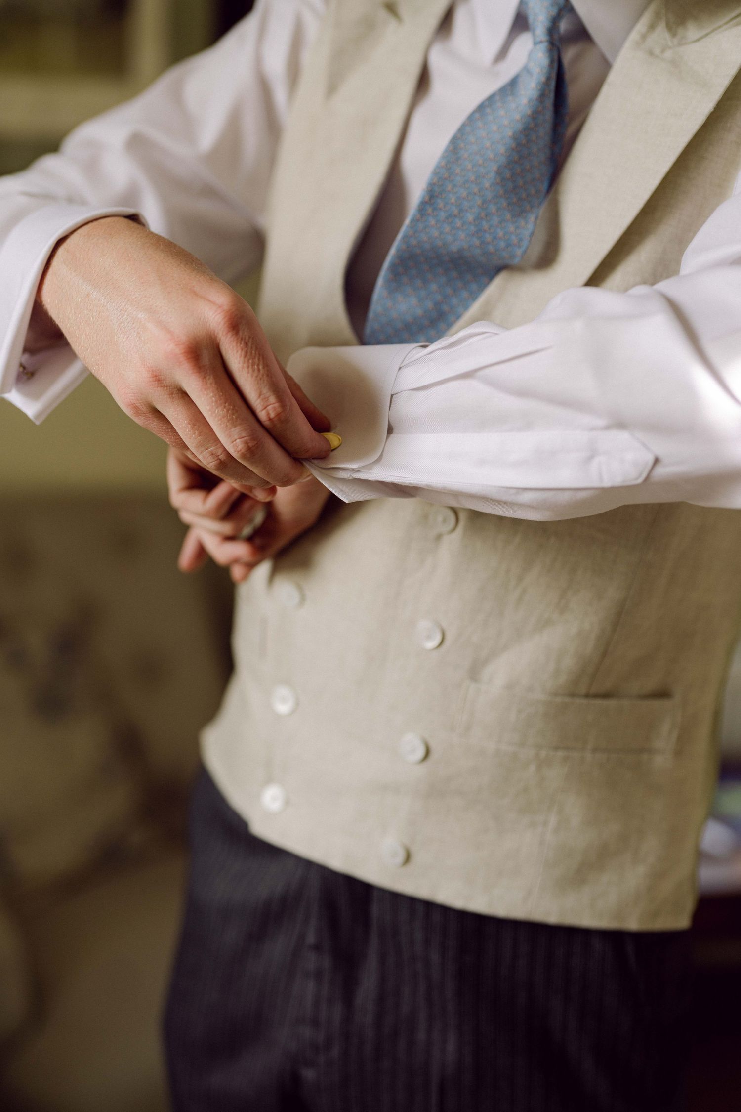 Groom adjusting cufflinks at his wedding