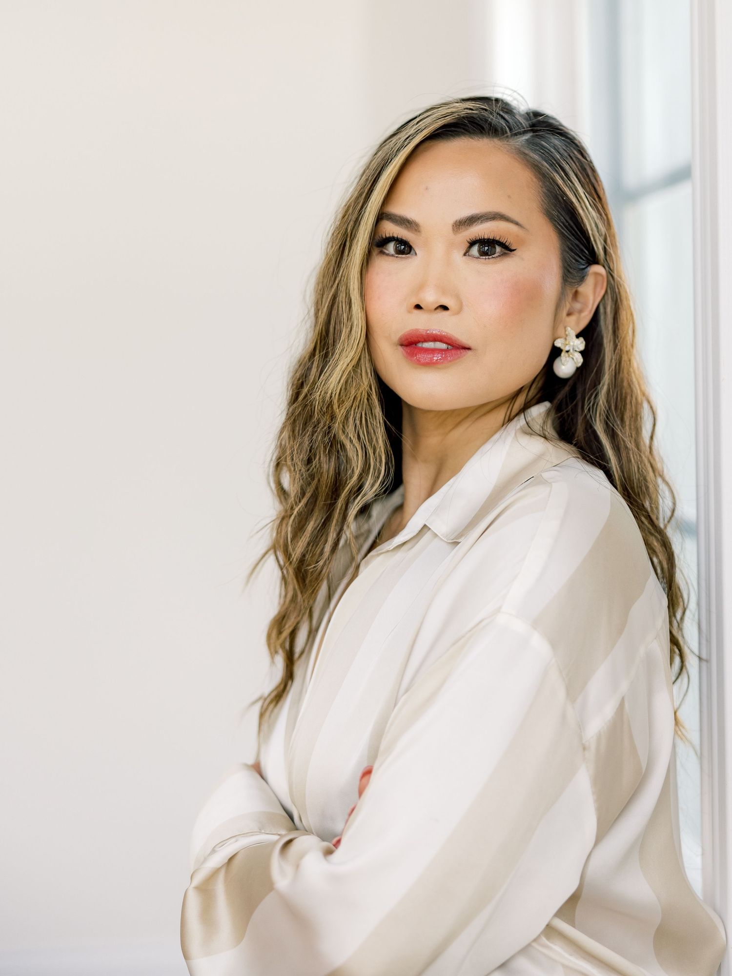 Woman in white button-down shirt poses in four sequential photos with different expressions against bright background.