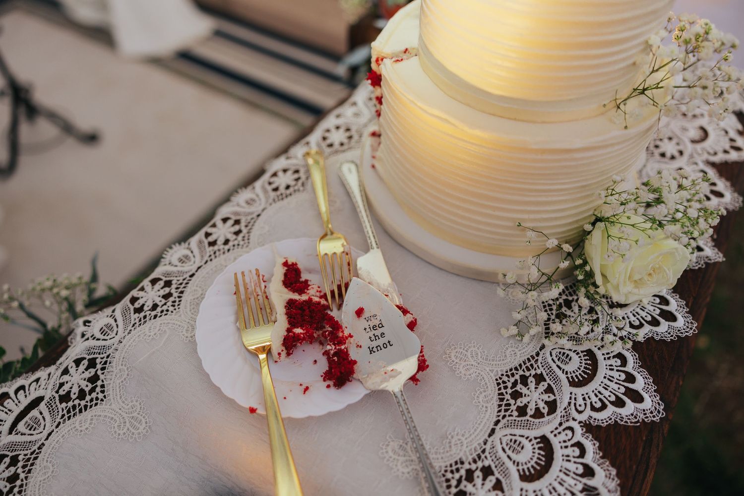 White paper lanterns with floral decorations on lace tablecloth at wedding reception.