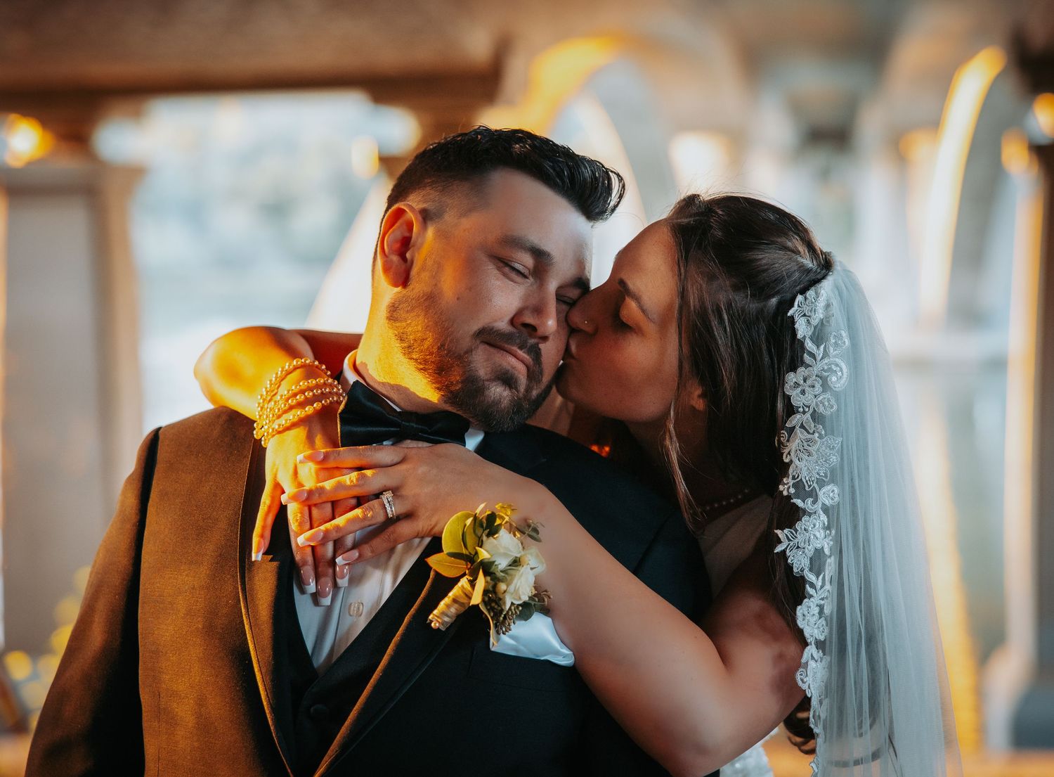 A romantic wedding couple shares an intimate moment during their sunset photoshoot in a warmly lit setting.