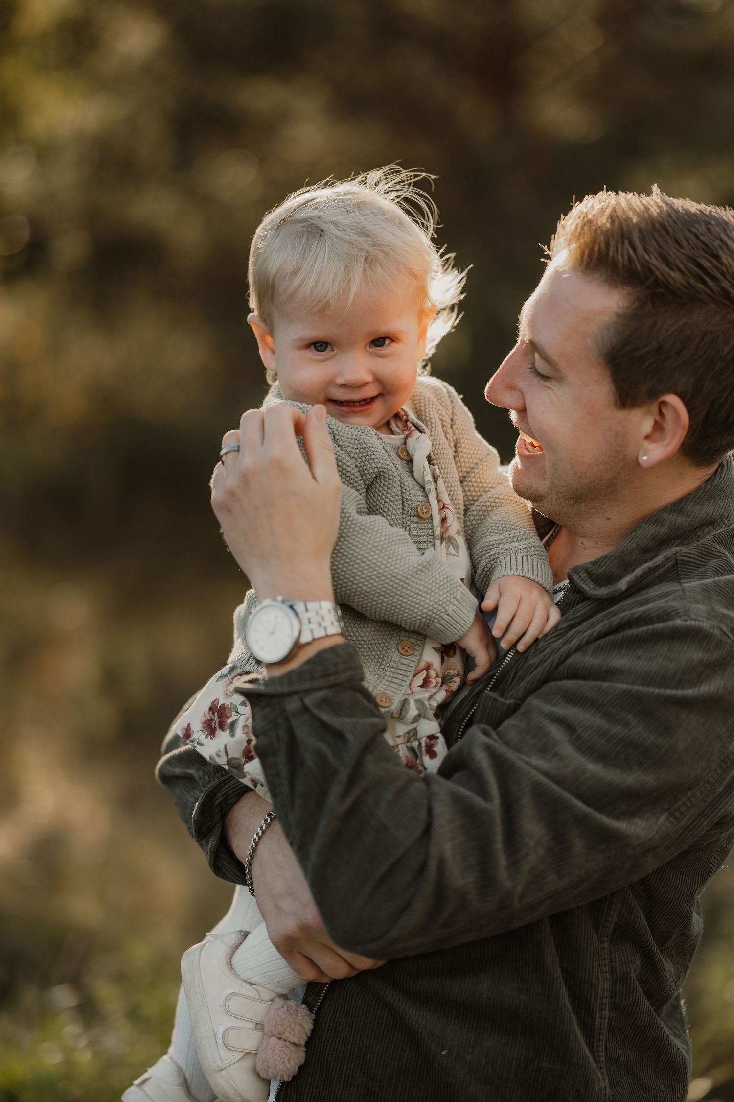 A joyful moment between parent and child playing together outdoors during a golden sunset.
