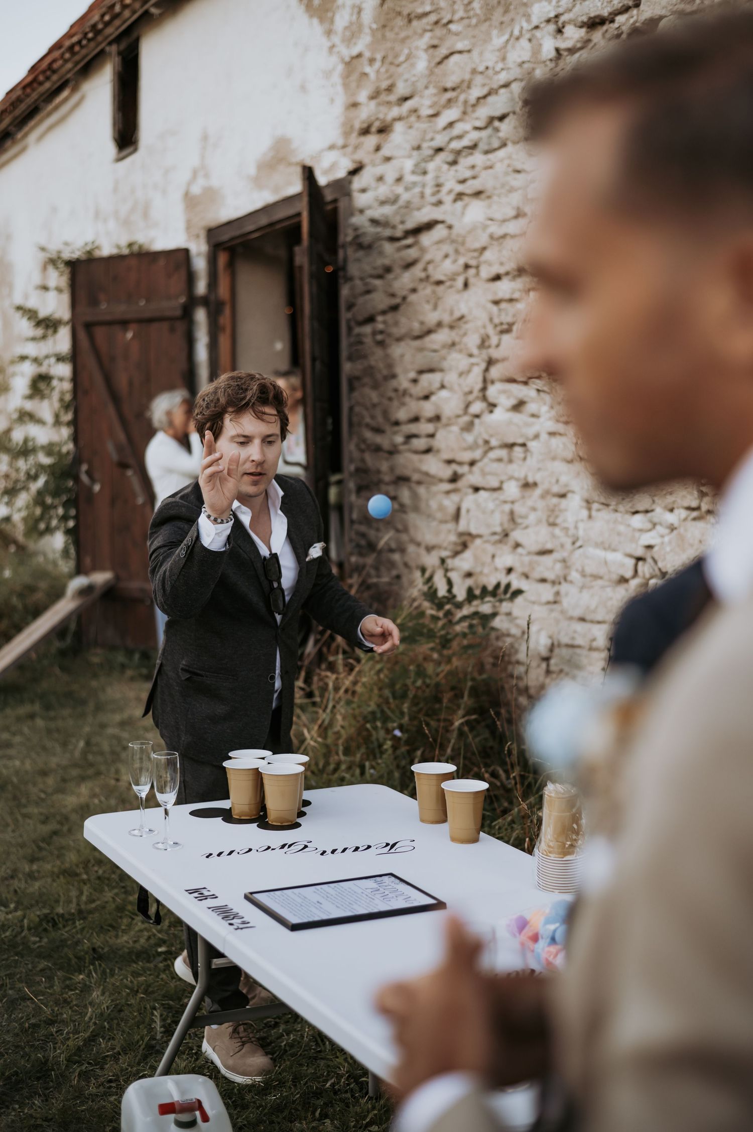 A casual outdoor game being played at a rustic wedding reception.