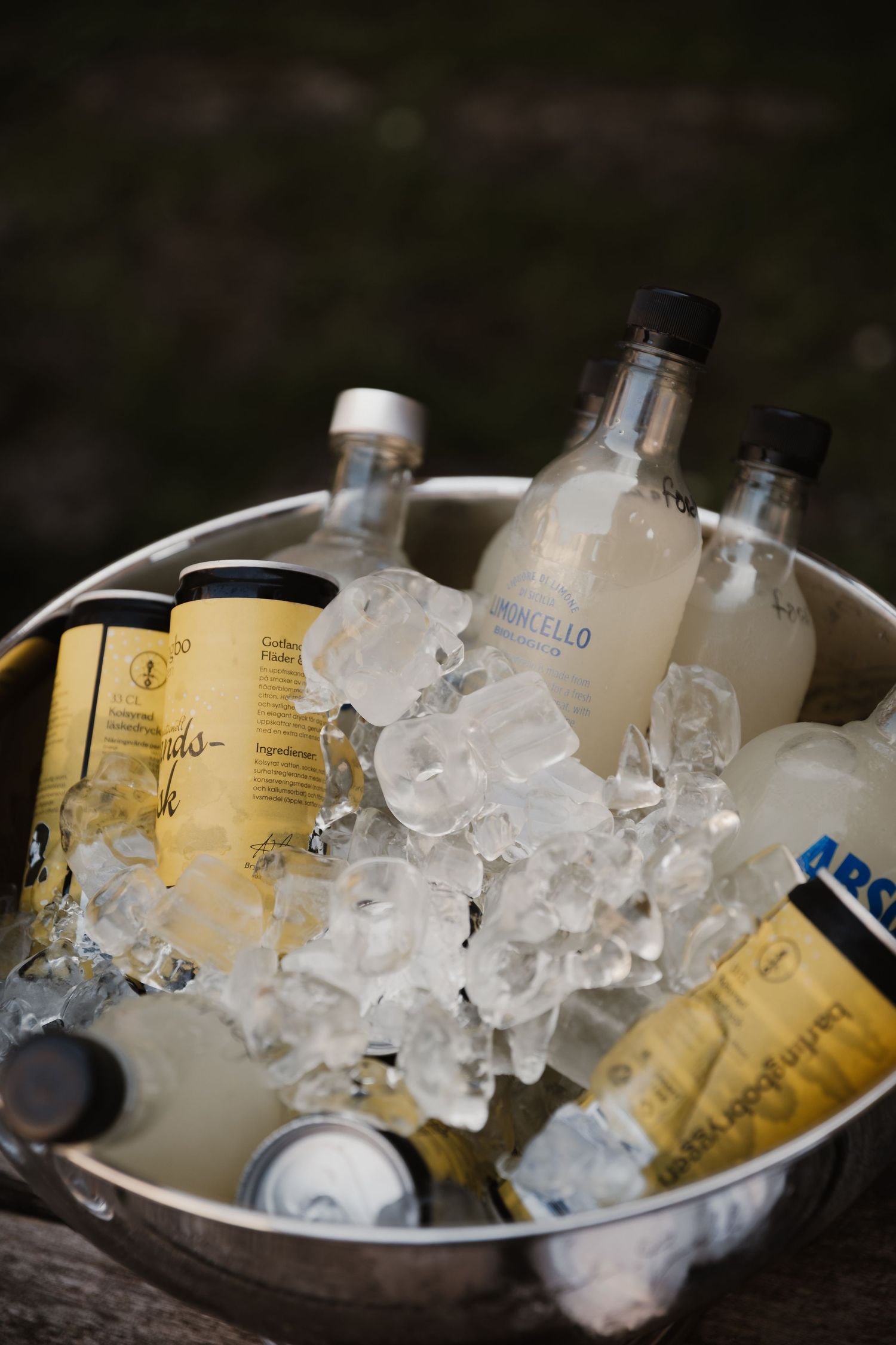 Glass bottles of wine chilling in ice bucket with crushed ice cubes at a bar or restaurant setting.