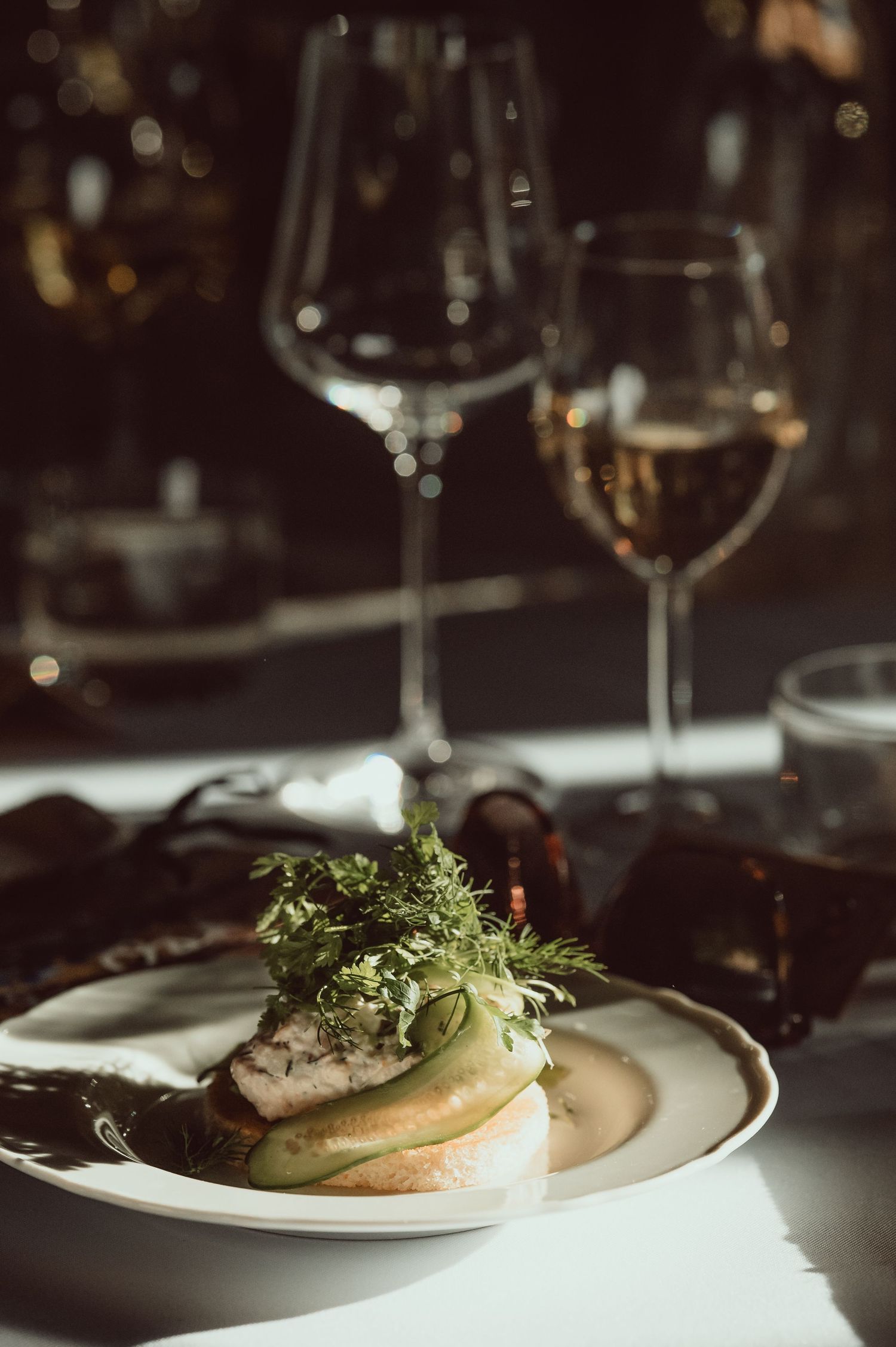 Elegant plated dish with microgreens garnish served on white plates in a fine dining restaurant setting.