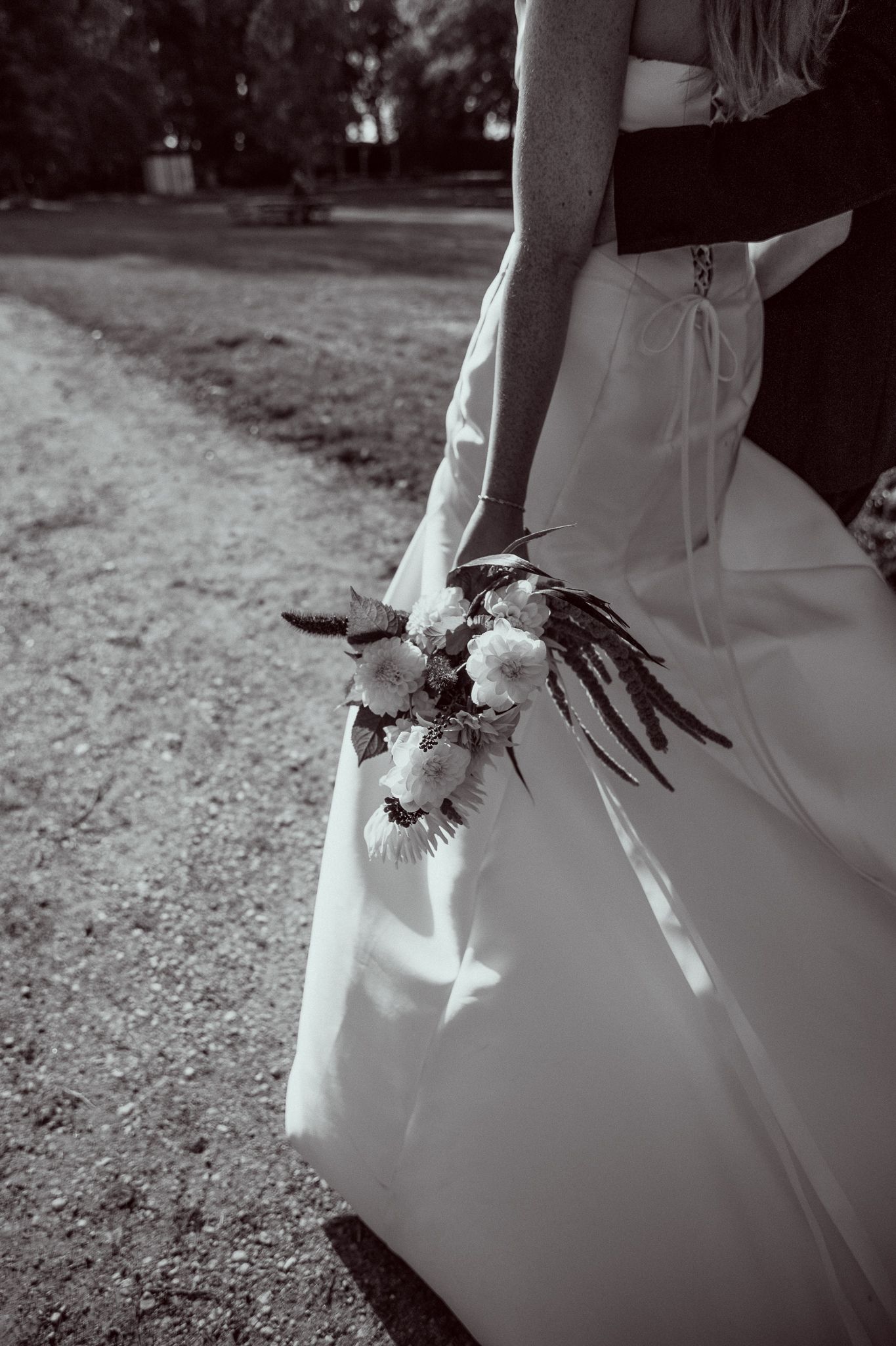 Black and white sequence showing a wedding dress train flowing in the breeze with delicate floral details.