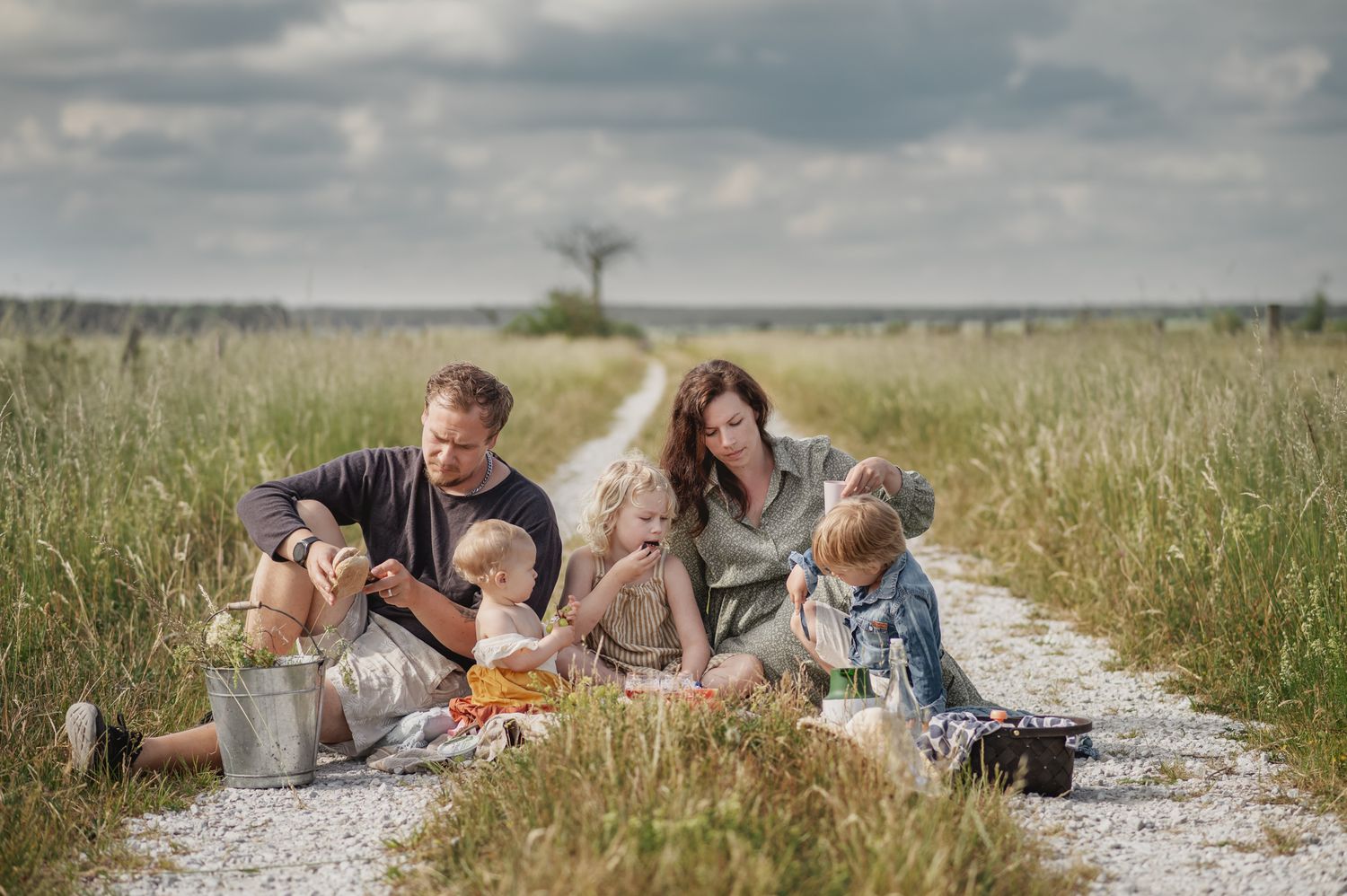 People relaxing together on a grassy path through a summer meadow field on a sunny day.