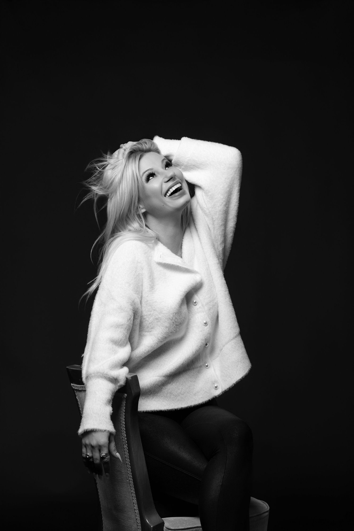 A dramatic black and white fashion photo series showing a person in a white sweater against a dark background.