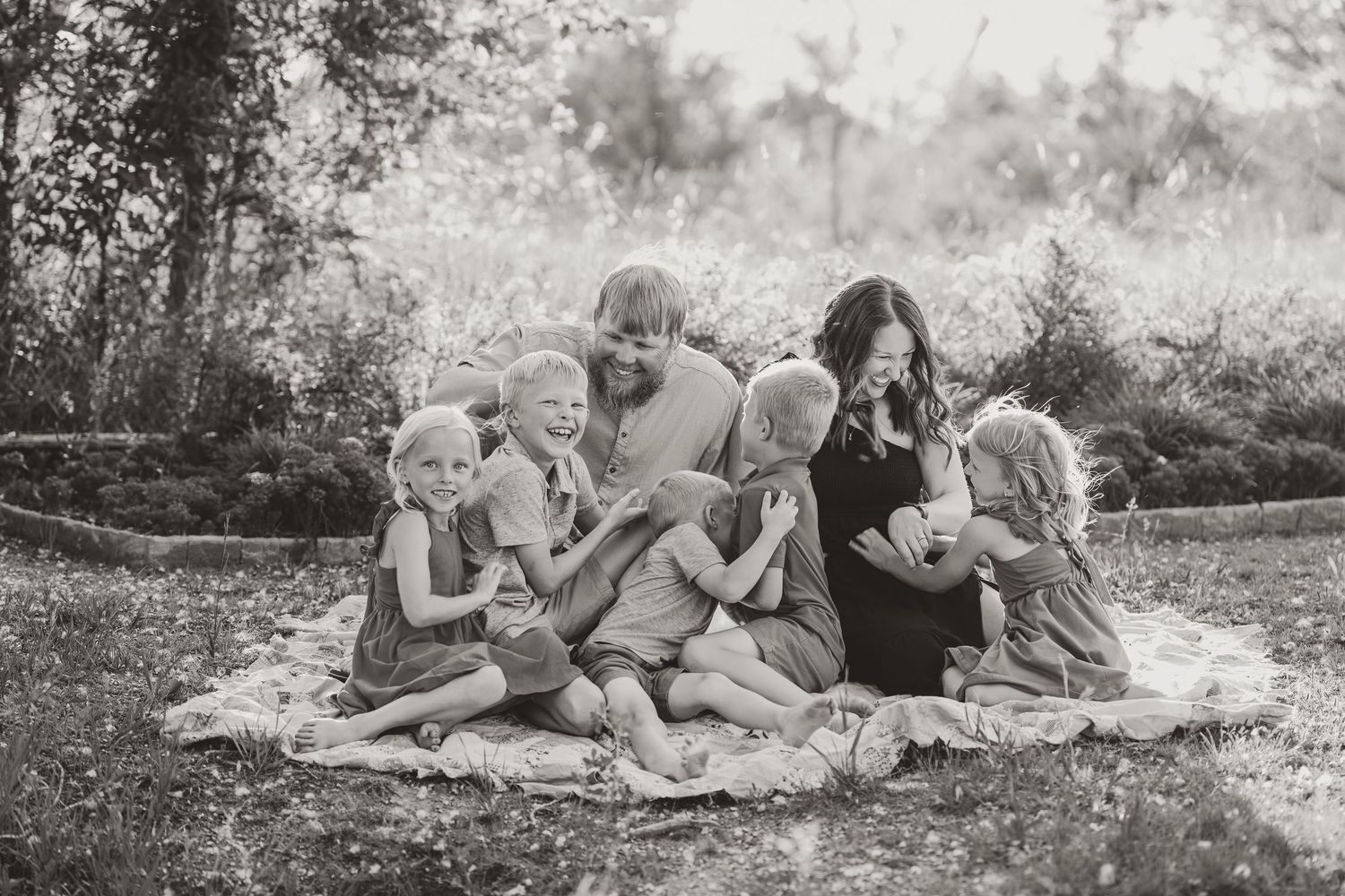 Vintage black and white photographs showing people relaxing on blankets in a park or outdoor setting.