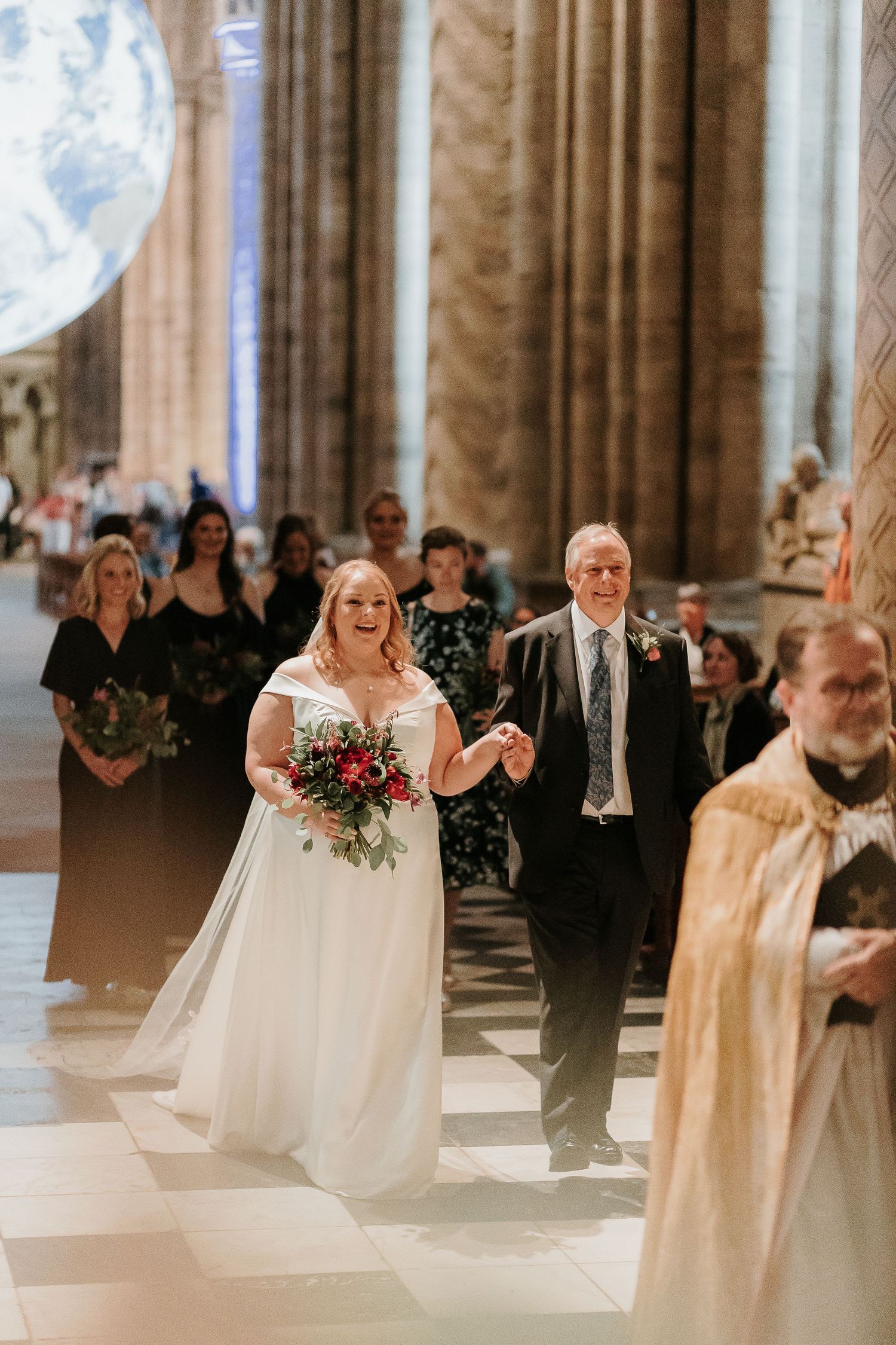 A wedding ceremony taking place inside a grand cathedral with ornate stone columns.