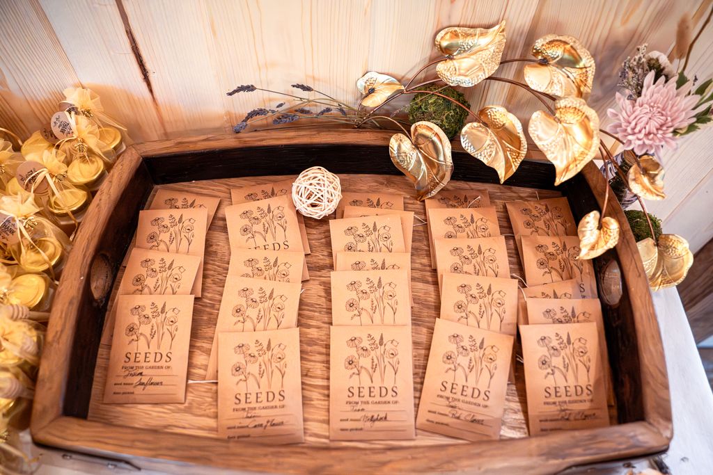 Brands photography of flower packets in a rectangular wooden bowl accompanied with flowers.