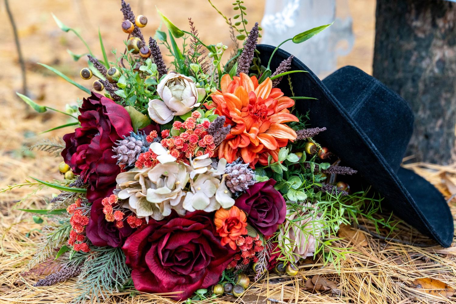 Brands photography of a bouquet of flowers accompanied by at black cowboy hat.