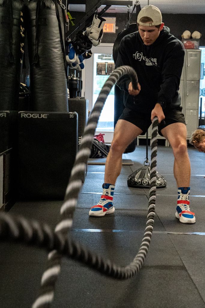 Brands portrait of a gym goer using battle ropes.
