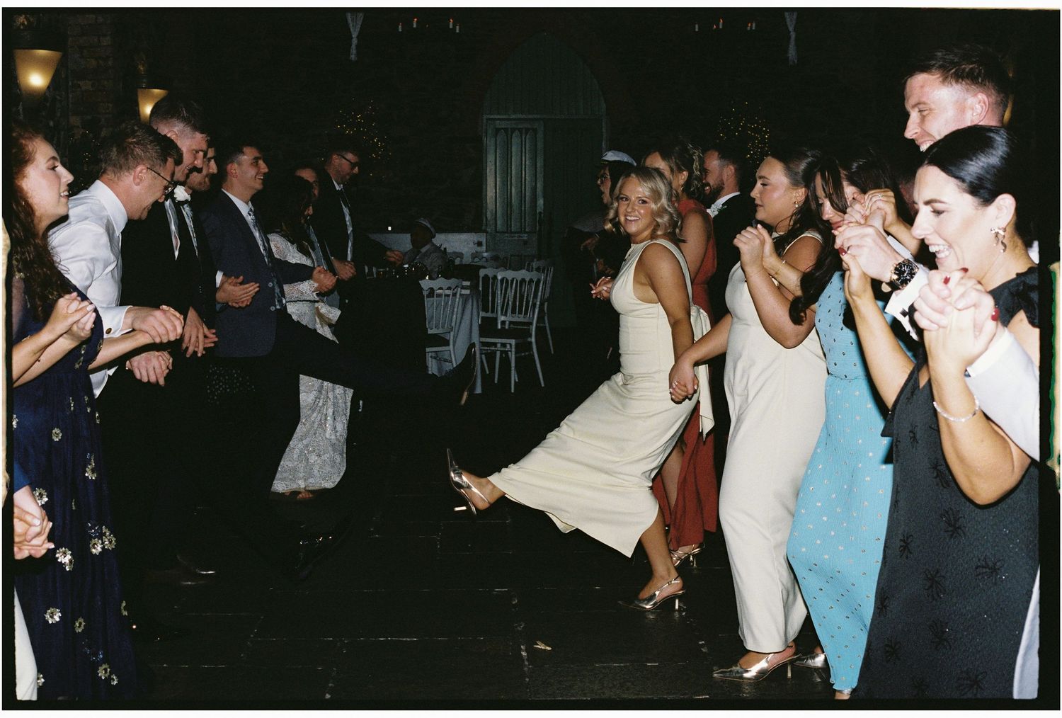 Wedding guests dancing and mingling at an evening reception party.