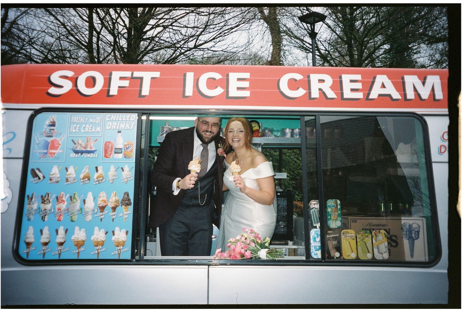 Vintage ice cream truck with 'Soft Ice Cream' sign parked on a residential street during winter.