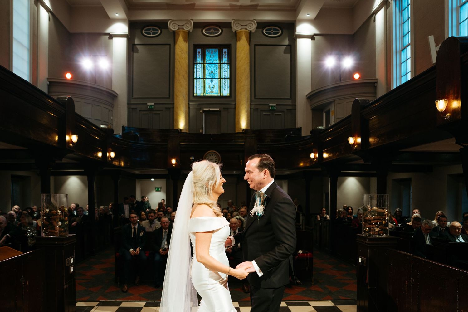 Wedding couple dancing in a dimly lit elegant ballroom venue.