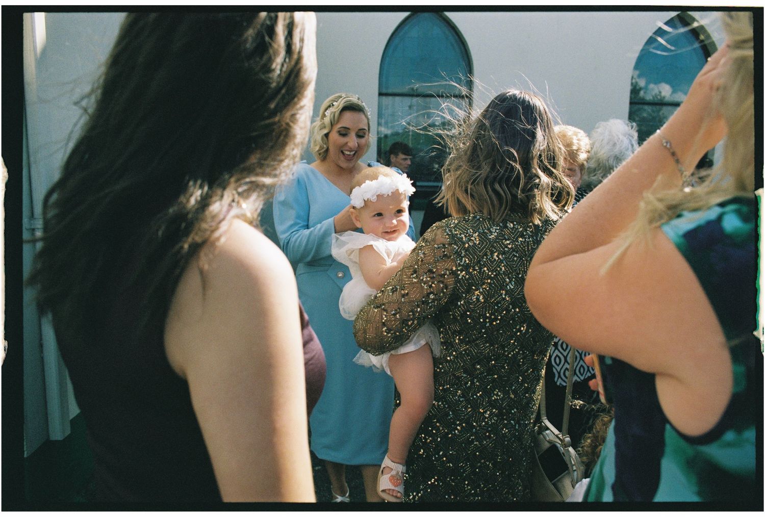 Wedding guests dancing and celebrating on an outdoor patio during a reception celebration.