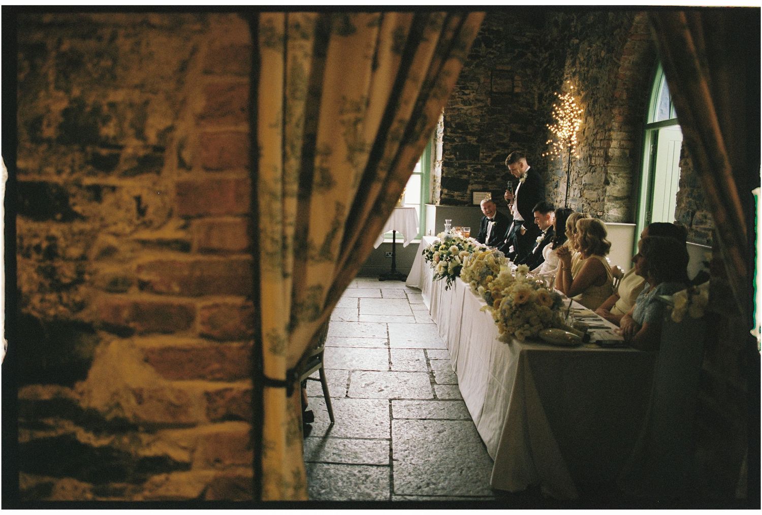 Interior of stone building with arched windows and ambient lighting.