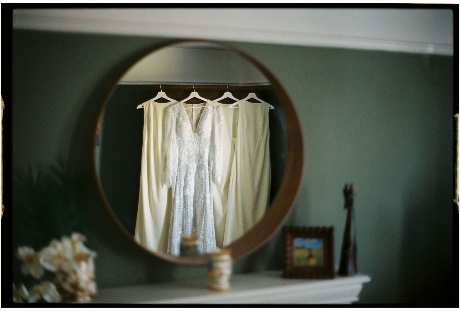 White dresses and robes hanging in a row against a dark wall, creating an elegant display.