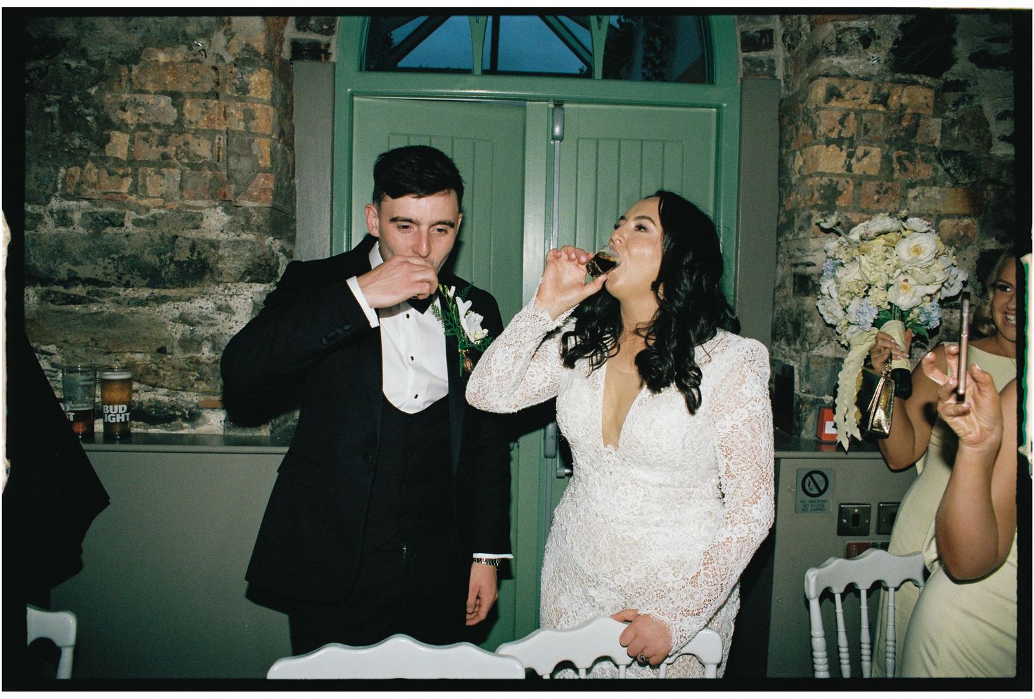 Wedding celebration candid moments captured in a rustic stone venue with turquoise door.