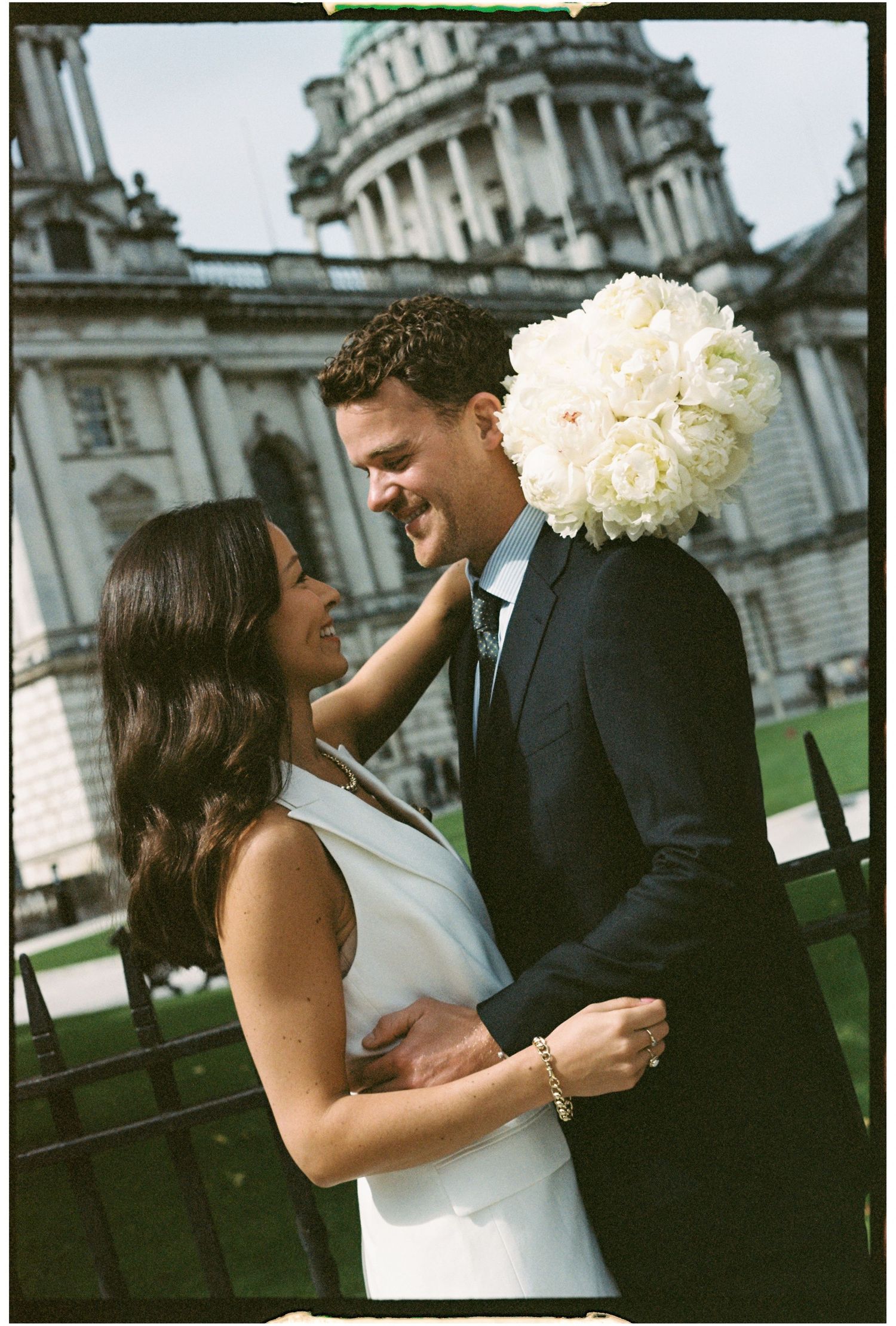 A romantic wedding photoshoot captured in multiple frames outside a grand historic building with white columns.